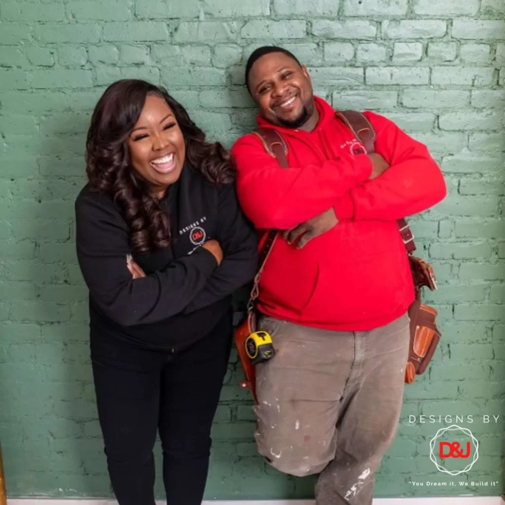 Happy couple standing in front of a newly renovated wall after home remodeling in New York City.